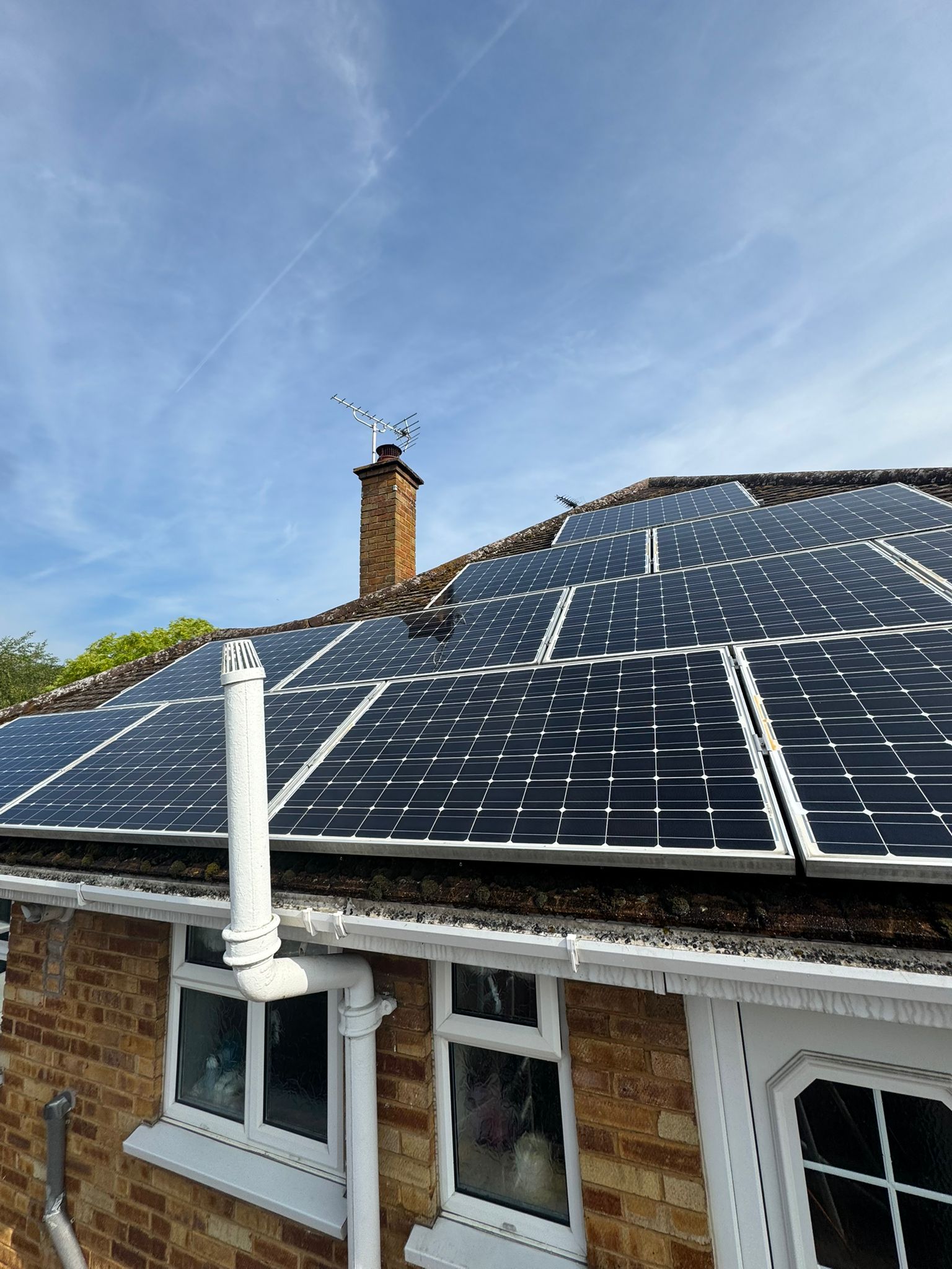 Solar panels on a house roof under a clear sky